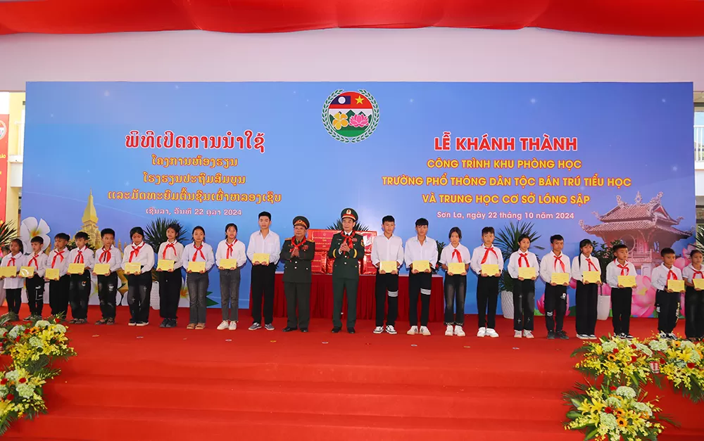 Đại tướng Phan Văn Giang và Đại tướng Chansamone Chanyalath tặng quà thầy và trò Trường Phổ thông dân tộc bán trú Tiểu học và Trung học cơ sở Lóng Sập -ảnh: Mạnh Hùng